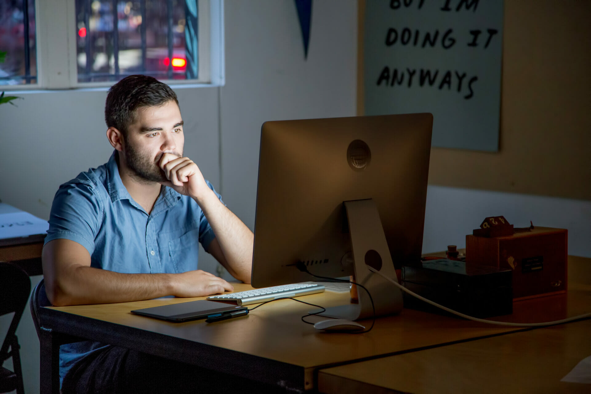  A man sat at a desk looking at a computer screen