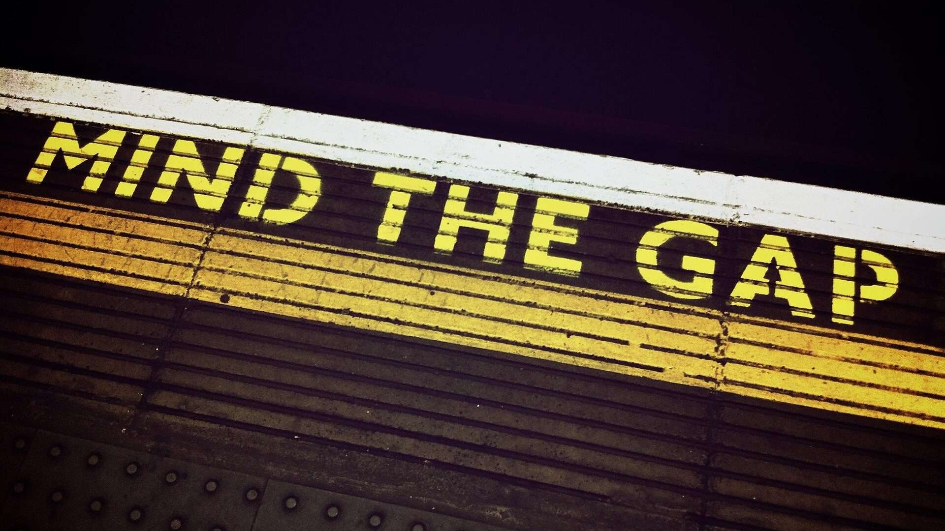 Hinweis „Mind the Gap“ an einer Bahnsteigkante – Symbolbild für das Erkennen und Schließen von Forschungslücken